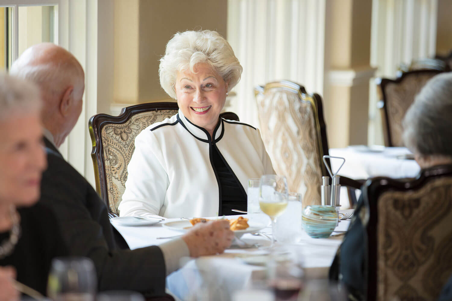 Senior woman seated with her husband enjoying a meal together