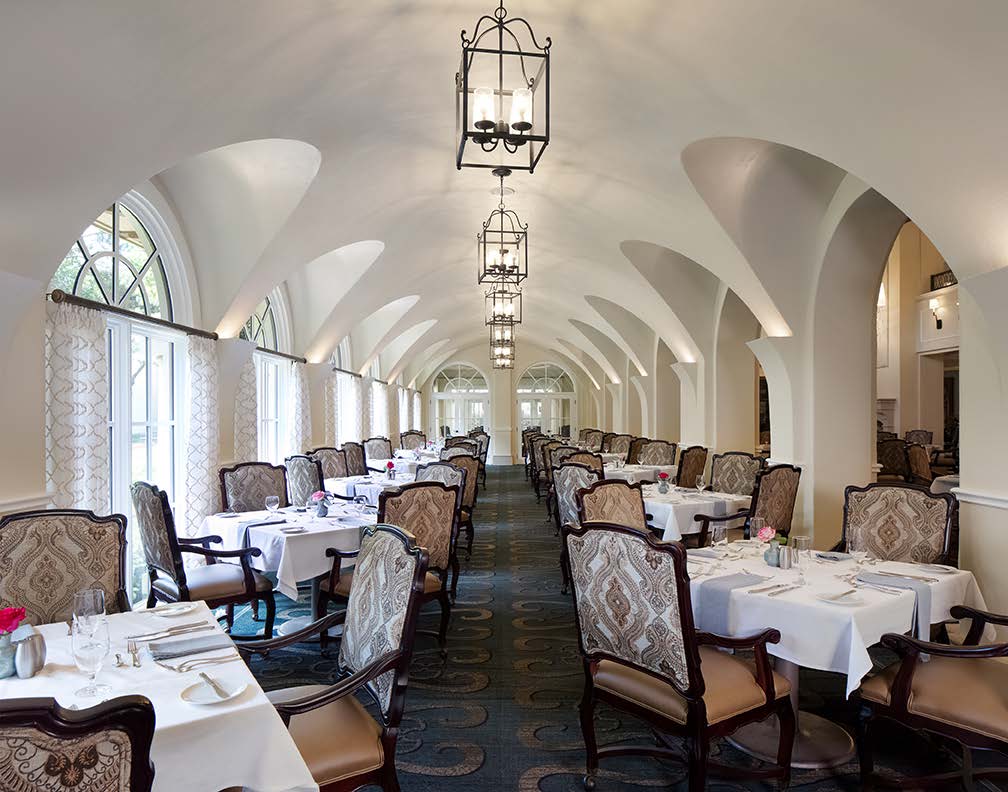 Stunning formal dining hall with a row of graceful arched windows and an opposite row of arched doorways